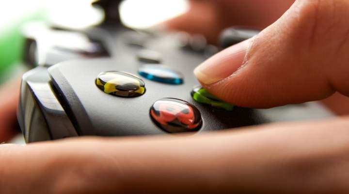 An extreme close up of a person's hands using an XBOX controller.